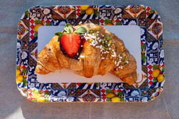 Italian breakfast, fresh baked butter croissant filled with ricotta cheese and jam, served outdoor...