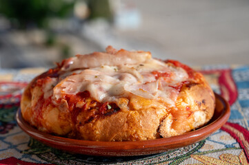 Fresh baked bread, pizza, focaccia or pala romana pizza with tomatoes, vegetables and cheese, street food in Palermo, Sicily, Italy, view on Mondello beach