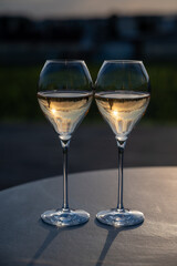 Glasses of white sparkling wine brut, grand reserve, champagne on green hilly vineyards in old wine making grand cru Ay-Champagne village in Vallee de la Marne, Champagne, France