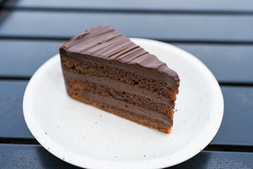 A decadent chocolate cake slice with rich layers and smooth frosting, Its moist texture and indulgent appearance captured in exquisite detail