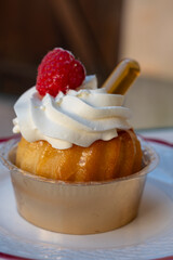 French cuisine, fresh baked baba au rum cake with chantilly cream, sweet dessert with rum close up