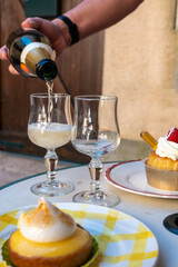 One French lemon tart or tartalette with white eggs meringue and glasses with champange sparkling wine