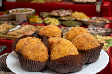 Arancini Sicilian, deep-fried rice balls made with risotto, filled with ingredients mozzarella, ragu, peas, coated in breadcrumbs fried to crispy, brown on market in Palermo, Sicily