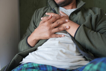 Man suffering chest pain laying on bed 