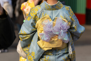 Young girl wearing Japanese kimono standing in front of Sensoji Temple in Tokyo, Japan. Kimono is a Japanese traditional garment. The word "kimono", which actually means a "thing to wear"