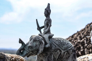 Stone statue of young Buddha riding an elephant