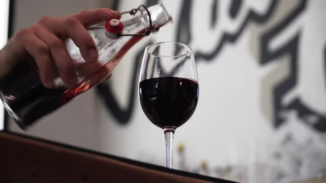 Person Pouring Red Wine In A Glass At The Bar Counter In Sydney, Australia. Close-up Shot