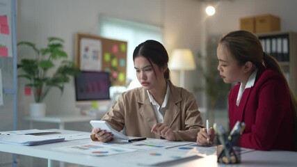 Businesswomen discussing financial reports in office