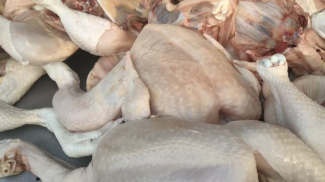 Close-up of raw chicken meat pieces, freshly cut and ready for cooking. Unprocessed poultry meat commonly found in traditional markets. Suitable for food or culinary content.
