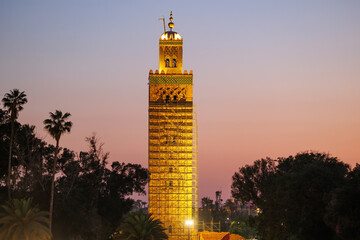 Elevated sunset street view of market stalls at Jemaa el-Fnaa in the Old Town Medina area of Marrakech with 12th century Koutoubia Mosque in the background, west Morocco 