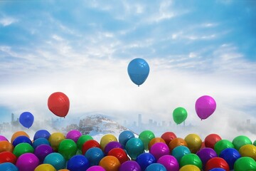 Many colourful balloons above snow