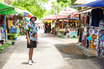 A cheerful tourist in a vibrant shirt walks through a Thai street market, enjoying the atmosphere and connecting with local culture