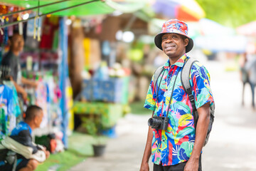A cheerful tourist in a vibrant shirt walks through a Thai street market, enjoying the atmosphere and connecting with local culture