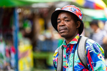 A cheerful tourist in a vibrant shirt walks through a Thai street market, enjoying the atmosphere and connecting with local culture