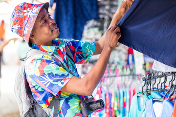 A cheerful tourist in a vibrant shirt walks through a Thai street market, enjoying the atmosphere and connecting with local culture