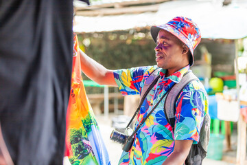 A cheerful tourist in a vibrant shirt walks through a Thai street market, enjoying the atmosphere and connecting with local culture