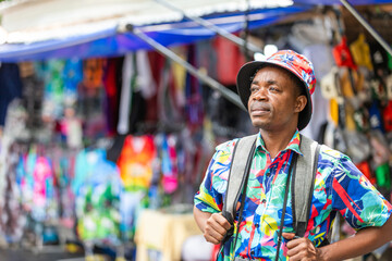 A cheerful tourist in a vibrant shirt walks through a Thai street market, enjoying the atmosphere and connecting with local culture