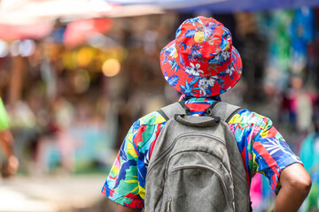 A cheerful tourist in a vibrant shirt walks through a Thai street market, enjoying the atmosphere and connecting with local culture