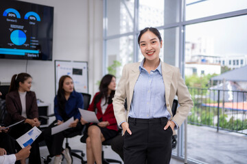 Young asian businesswoman smiling during office meeting with coworkers