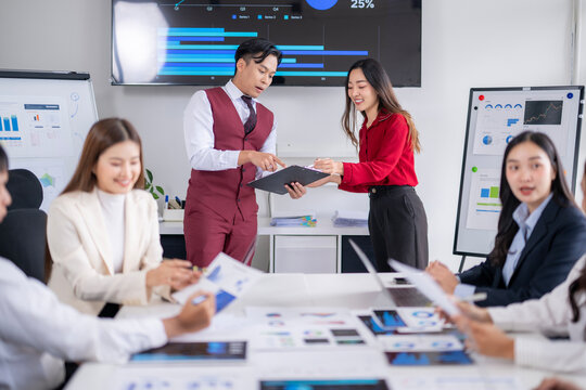 Asian businesspeople discussing charts and graphs during meeting