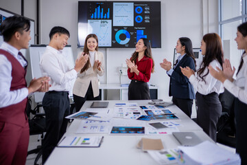 Business team clapping hands after successful presentation in meeting room