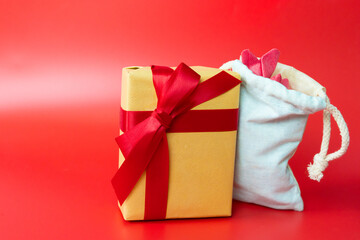 minimal flat lay valentine's day decoration item with red gift box and paper heart on red background