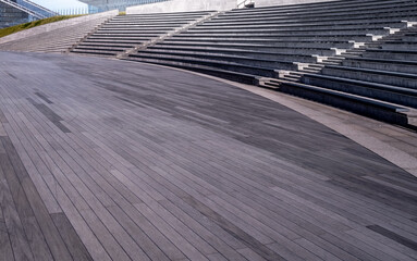 A modern amphitheater with long seats and a stage.