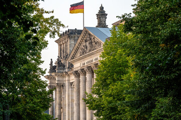 The entrance portal to the Reichstag in Berlin seen through some trees