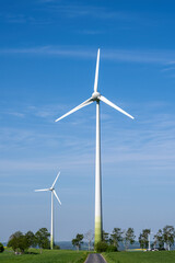 Modern wind turbines with a small country road seen in Germany