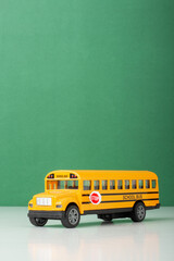 Yellow School Bus Toy with Green Background, back to school concept