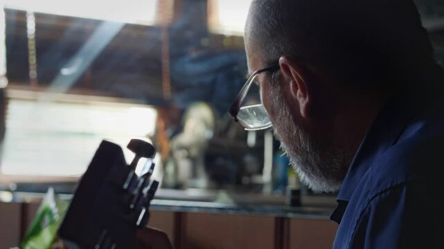 A contemplative and musical mood is captured by a close-up, low-angle view of a man playing a guitar, with the headstock and tuning pegs prominent, subtly lit from behind