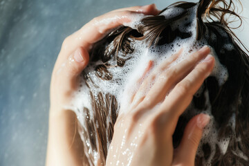 Girl washing hair with shampoo close up background..