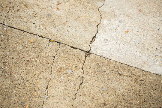 Close up shot of concrete floor with oblique linear cracking, in light brown and grey color, retro style