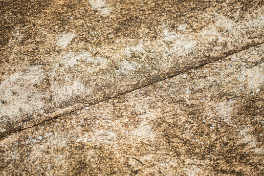 Close up shot of concrete floor with oblique linear cracking, in dirty light and dark brown color, retro style