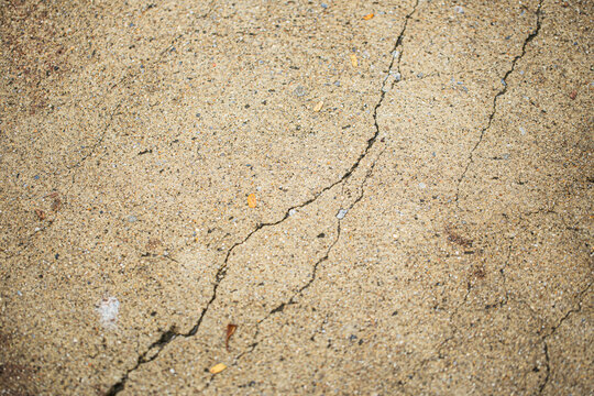 Close up shot of concrete floor with oblique cracking, in light brown color, retro style