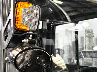 Close view of truck lighting system with city skyline in background during daytime