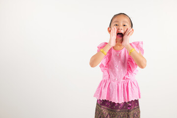 Portrait Thailand kid girl smiling traditional Thai dress costume use hand covering her mouth,...
