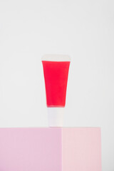 Red lipstick, small tube, and empty space with props on white background.