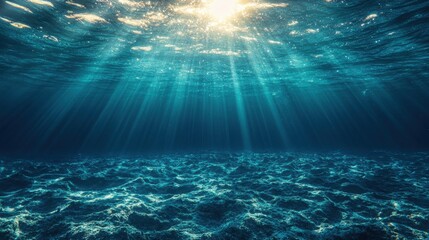 Sunlight beams penetrate clear ocean water, illuminating the rocky seabed beneath the calm surface.