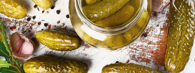 Pickled  cucumbers in bowl on wooden rustic board