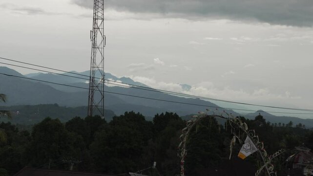 Timelapse Clouds roll over Munduk&rsquo;s green hills with ceremonial decor penjor pole, Bali, Indonesia.