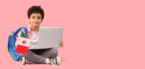 Little schoolboy with Mexican flag and laptop sitting on pink background with space for text