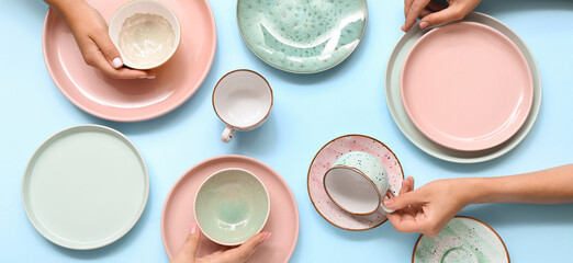 Female hands with beautiful table setting on blue background