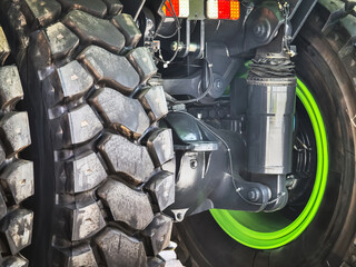 Close-up view of a rugged truck tire showcasing intricate details and vibrant green highlights during daylight