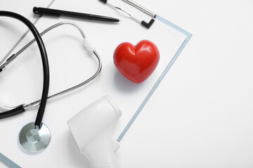 Stethoscope, infrared thermometer, heart and clipboard on grey background