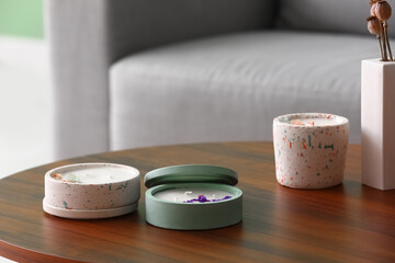 Holders with candles and dry poppy heads on table in room, closeup