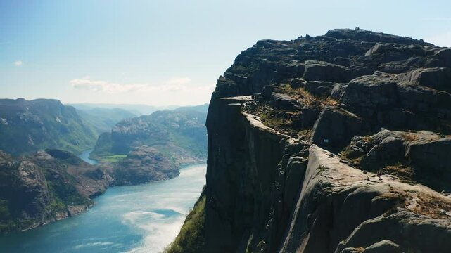 Breathtaking view of Preikestolen with dramatic cliff face overlooking Lysefjord. Majestic scale of natural landmark and waters of fjord in Norway