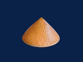 The dark blue background in the picture is a beautiful, intricately woven basket made from bamboo painted in beautiful brown colors. There is a head cover inside that is made into a circle. 