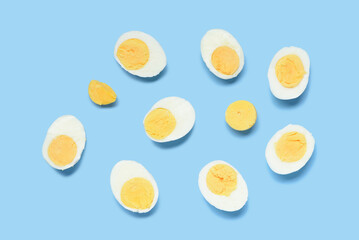 Halves of tasty boiled eggs on blue background