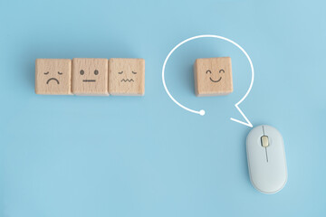 smiling face on wooden cube block inside speech bubble frame with white computer mouse  for customer service evaluation and satisfaction survey, human resource recruitment, mental health concepts